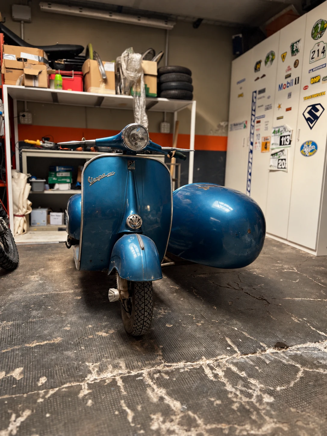 The blue Vespa 150 VBB1 with sidecar in the workshop, showing its current state before the planned custom project.