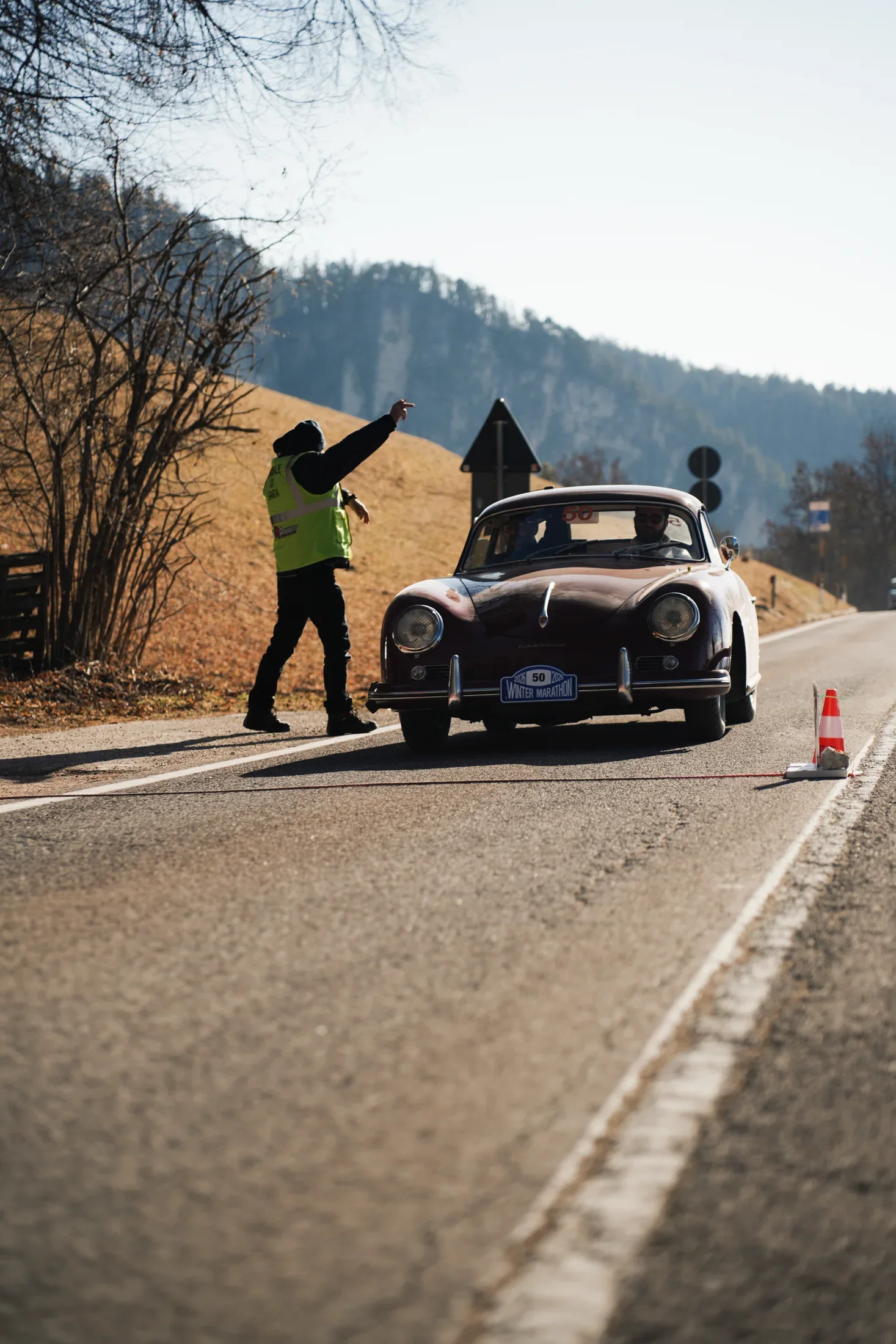The Porsche 356 in front of a hotel in a snowy alpine village.