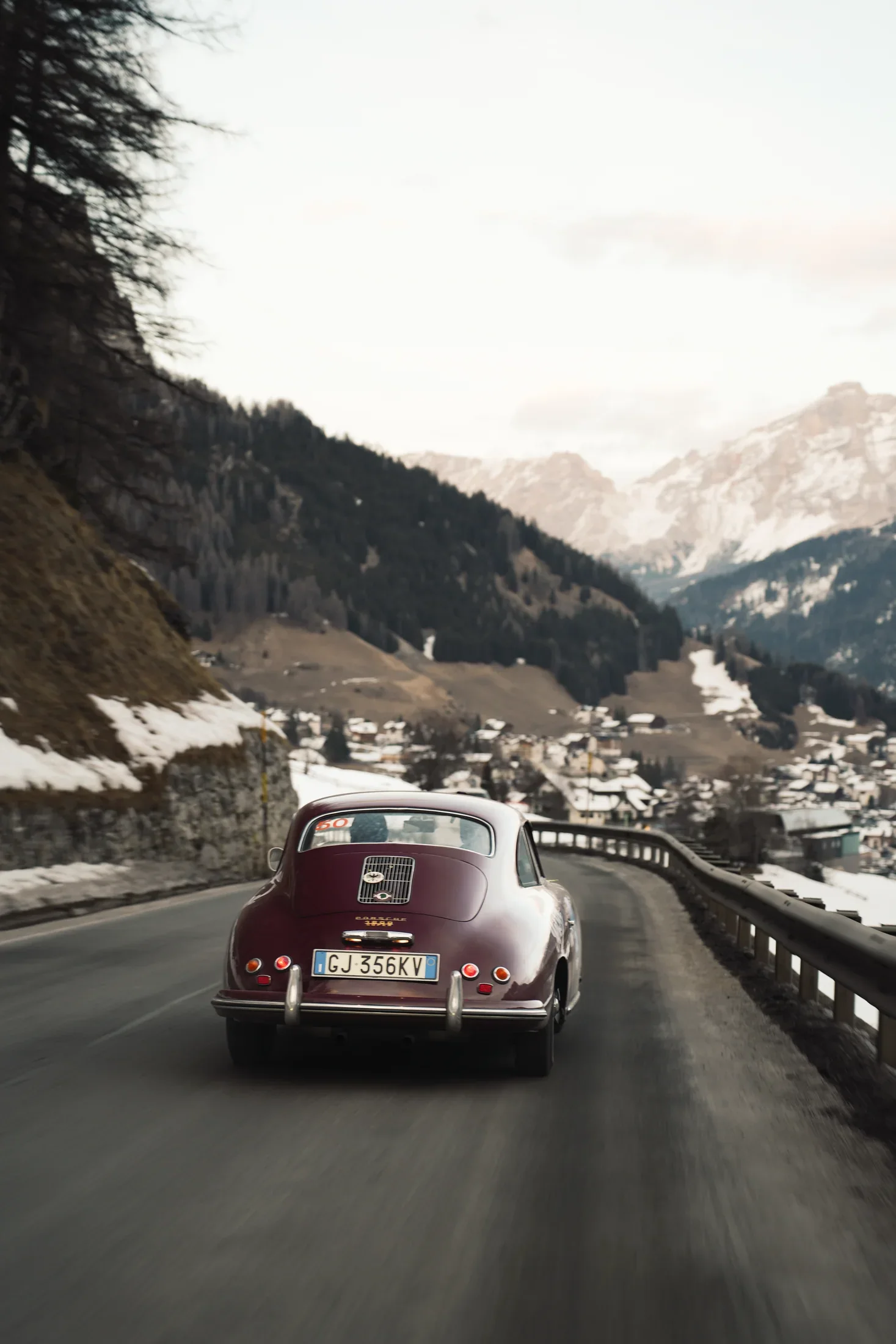 The Porsche 356 descending toward an alpine village.