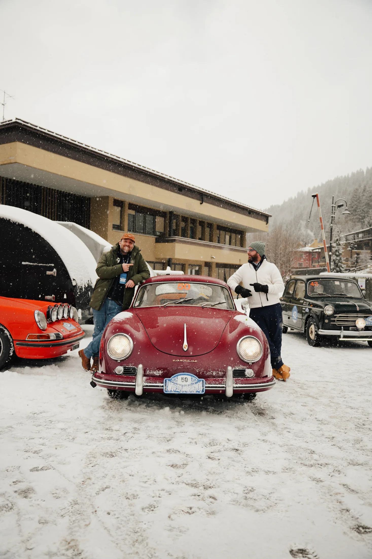 The Porsche 356 parked in the snow among other historic cars.