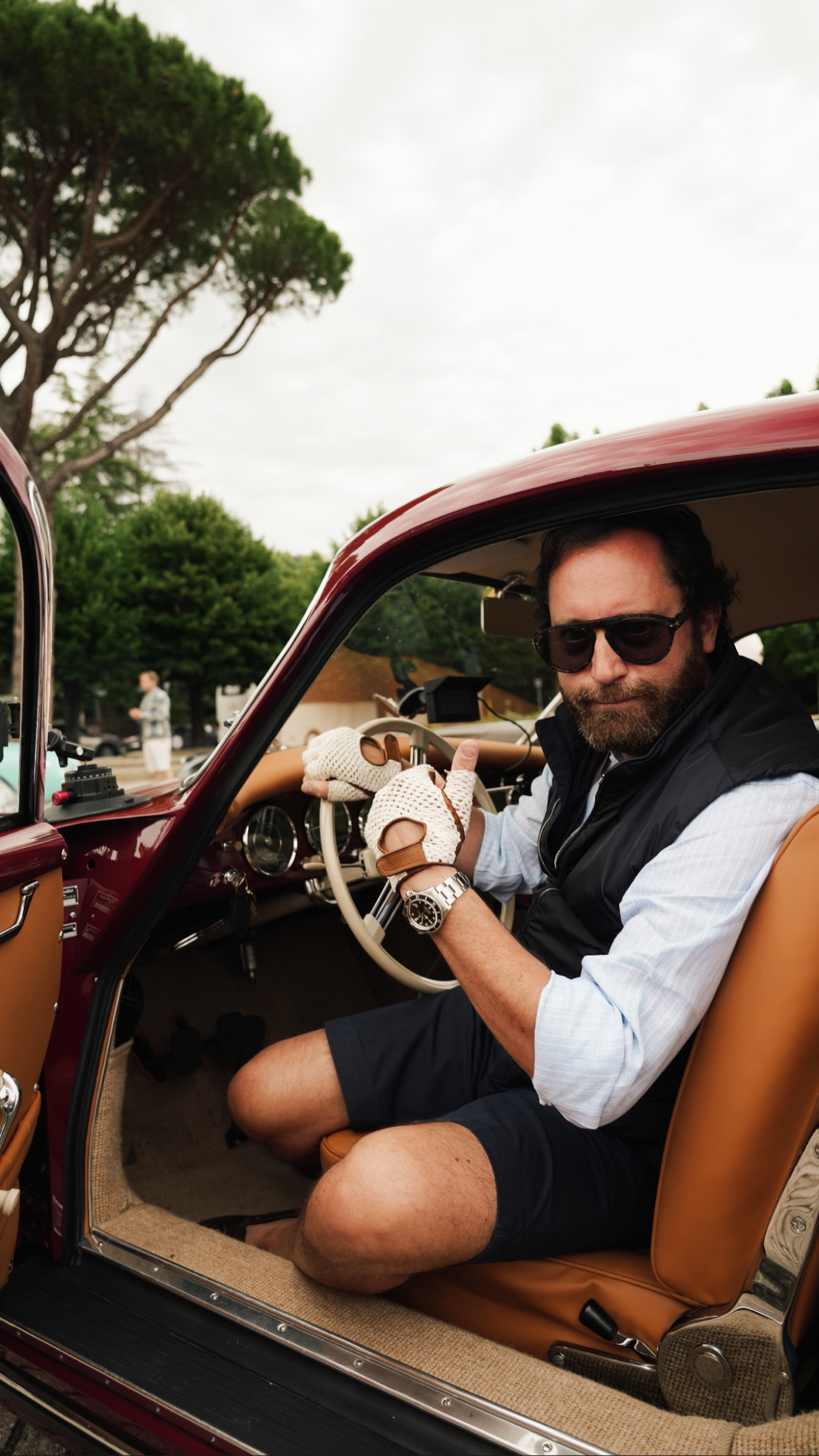 Andrea seated inside a burgundy Porsche 356