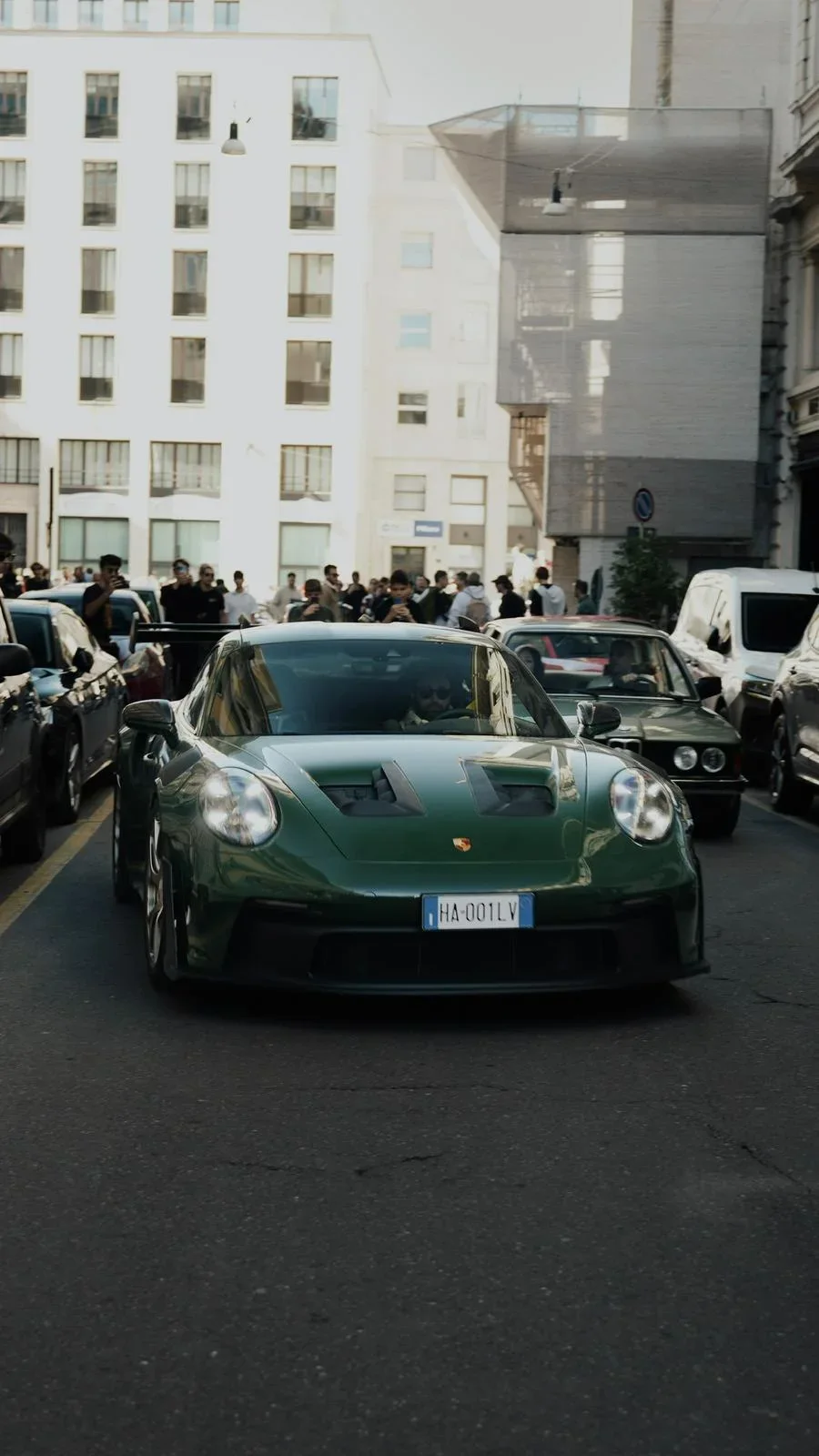 Madame Claude, a green 2025 Porsche 992 GT3 RS driving through Milan