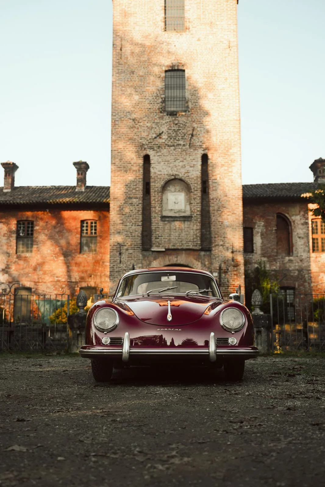 Princess Grace, a burgundy Porsche 356 AT1 in front of a brick tower